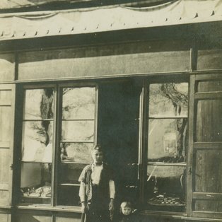 Photo d'un groupe de personne devant un commerce ancien