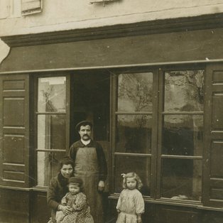 Photo du cordonier et les enfants devant  le commerce