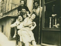 Photo d'un groupe de personnes souriantes devant un magasin de chapeaux