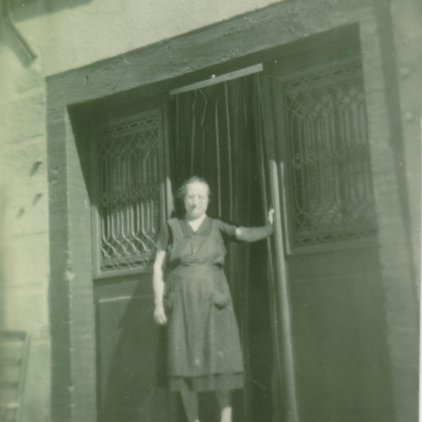 Photo de Jeannette Raynal, née Lacoste devant son commerce